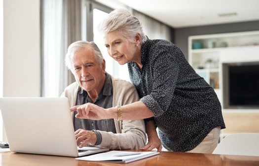 Elderly couple reviewing financial plans on a laptop